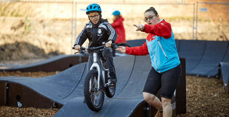 Children being coached on the pumptrack