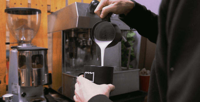 Milk being poured into fresh coffee at Dirt Factory