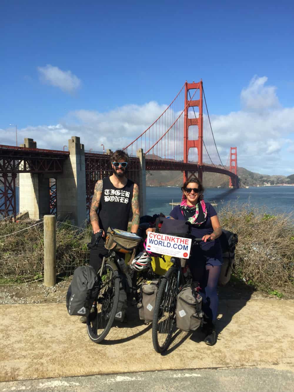 Chris and Ties touring America on bikes, stood outside San Francisco bridge.